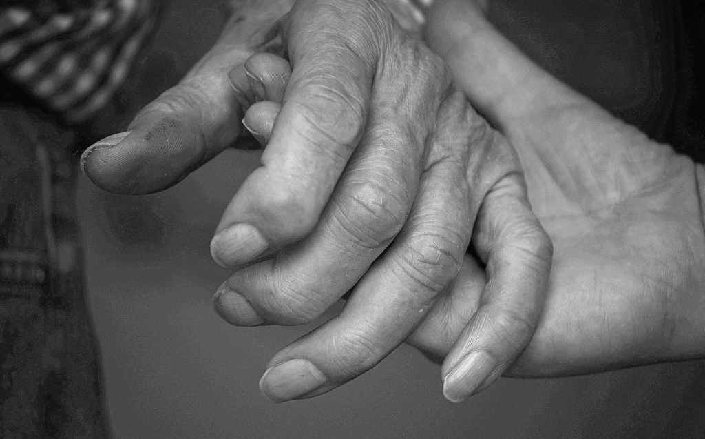 Two older adults holding hands