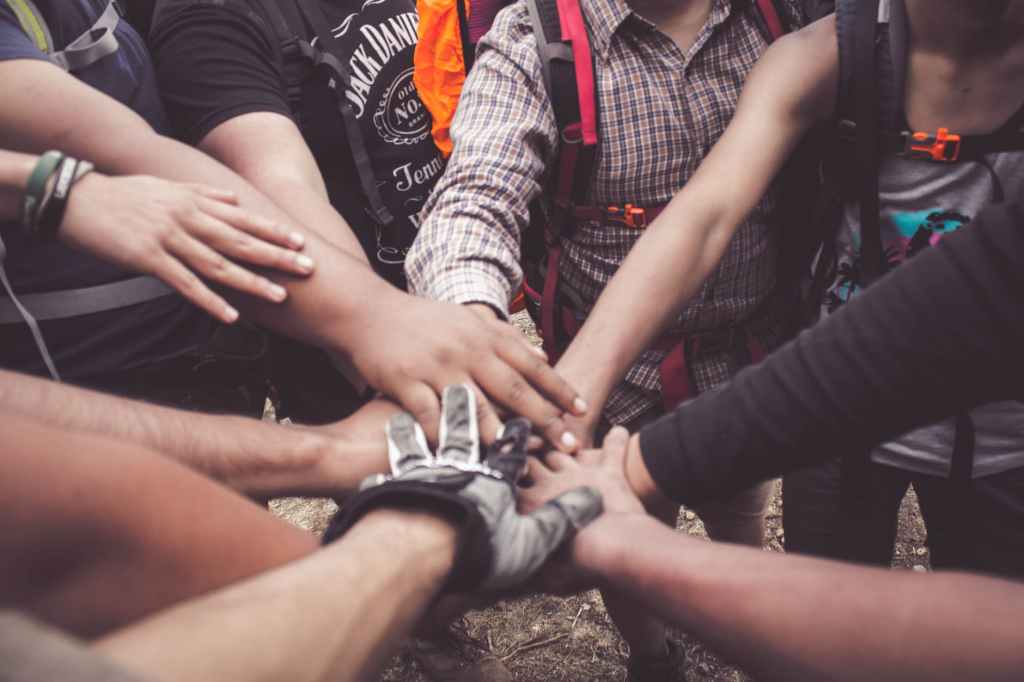 A team of people in a circle putting hands together